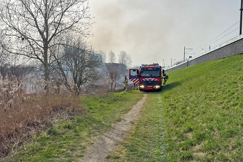 Brandweer rukt uit voor rietbrand langs spoor in Almere Buiten